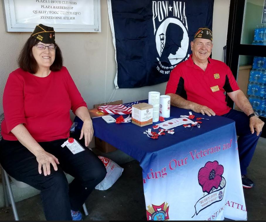Gail Engler and Joe Fitzgerald pass out Buddy Poppy pins and seeds at the QFC on Holman Road.